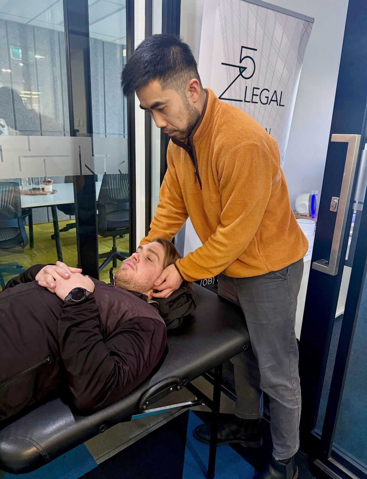 Philip Chau performing workplace physiotherapy treatment on portable table